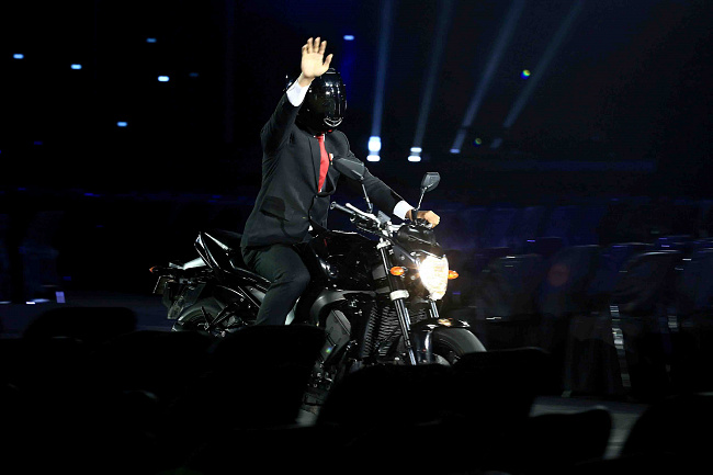 Presiden Joko Widodo mengendarai sepeda motor pada Upacara Pembukaan Asian Games ke-18 Tahun 2018 di Stadion Utama Gelora Bung Karno, Senayan, Jakarta, Sabtu (18/8).