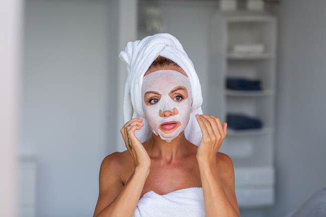 portrait-calm-caucasian-pretty-woman-with-towel-head-cosmetic-mask-face-face-skin-care-concept-female-relax-bed-home